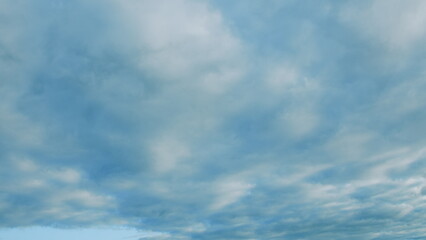 Obraz premium A beautifully calm blue sky adorned with soft, fluffy layered clouds creating a serene atmosphere