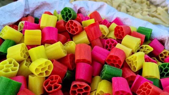 Colorful wheel-shaped soya fryums in red, yellow, green, and pink, sold raw and typically deep-fried before eating as crispy snacks.