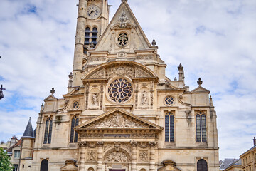 Obraz premium Facade of Église Saint-Étienne-du-Mont, a historic church in Paris Latin Quarter featuring Gothic and Renaissance architecture with ornate stone carvings, rose window, and clock tower