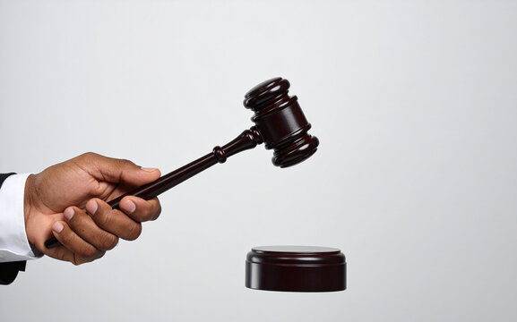 La mano de un juez con un mazo sobre la mesa del tribunal en juicio, concepto de justicia, ley, sistema judicial, autoridad legal y veredicto judicial culpable o inocente aislado en fondo blanco