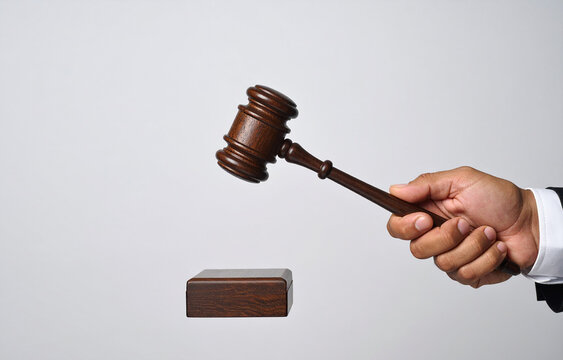 La mano de un juez con un mazo sobre la mesa del tribunal en juicio, concepto de justicia, ley, sistema judicial, autoridad legal y veredicto judicial culpable o inocente aislado en fondo blanco