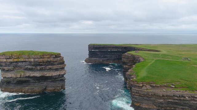 Aerial view of stunning Downpatrick Head coastal landmark with iconic Dun Briste sea stack. Dramatic cliffs and waves. Raw beauty of Ireland's west coast. Wild Atlantic Way Signature Discovery Point.