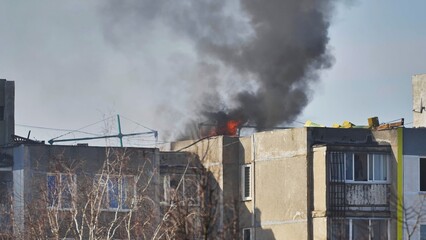 Building fire emergency with black smoke billowing from residential apartment block roof © Довидович Михаил