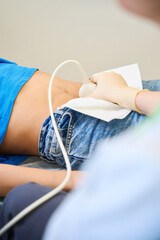 Adult woman receiving ultrasound scan in medical room