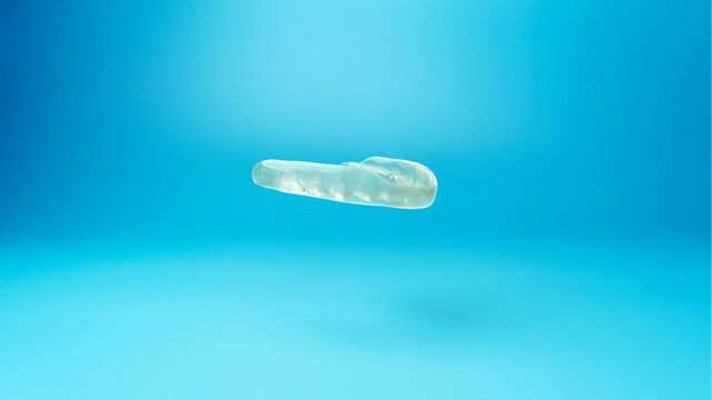 Individual myorelaxing mouthguard on a blue background. Muscle relaxant mouth guard or night mouth guard treatment of teeth grinding, bruxism and TMJ dysfunction