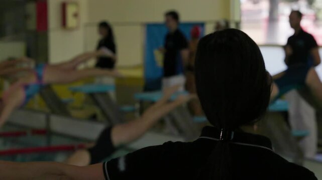 Swimming coach starting stopwatch during competition race