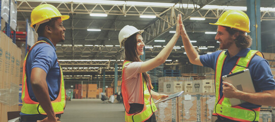 Group happy workers in the warehouse greeted each other with high-fives showing unity, encouragement cooperation and good spirits among employees in the warehouse organization. © ฺฺฺBoonterm