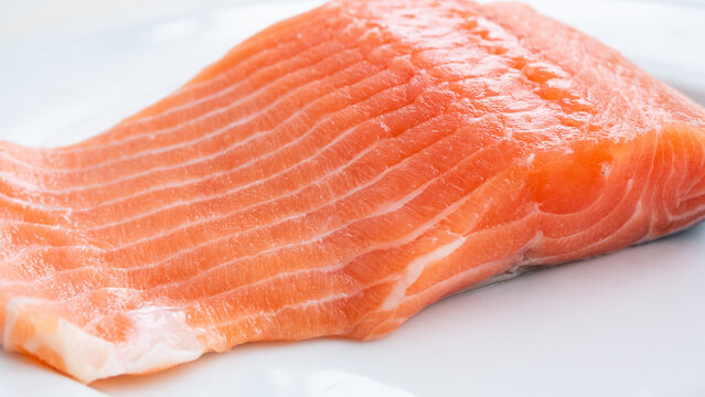 Salmon fillet captured up close in brilliant detail. The  bright orange juicy flesh fills the frame in a stunning way. Food inspired content.