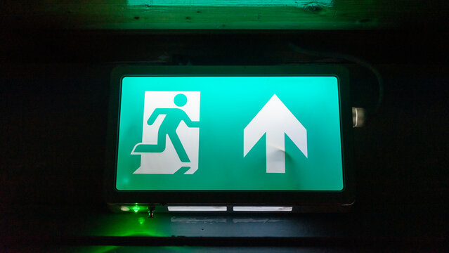 Emergency exit sign. Green fire exit sign closeup