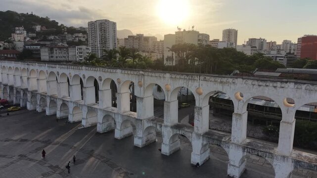 RIO DE JANEIRO, BRAZIL &ndash; NOVEMBER 2025: Aerial overhead shot of yellow tram riding on the top of Carioca Aqueduct (Arcos de Lapa), a famous landmark in old part of Rio de Janeiro, Brazil