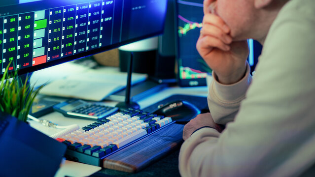 Stock market trader thoughtful analysis financial data charts monitor