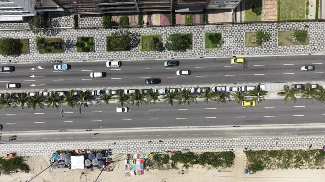 Drone top-down view of Copacabana coastal road with traffic and palm trees, Rio de Janeiro