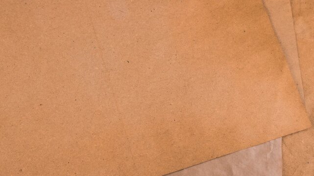 Handmade craft paper dyed with natural vegetable colorants in earthy brown, plum lavender and tan shades. Close-up texture of recycled sheets being stacked one on another for scrapbooking.