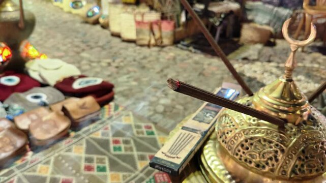 Close Up of Smoking Incense Stick Burning in Traditional Arabic Brass Mabkhara at Outdoor Market