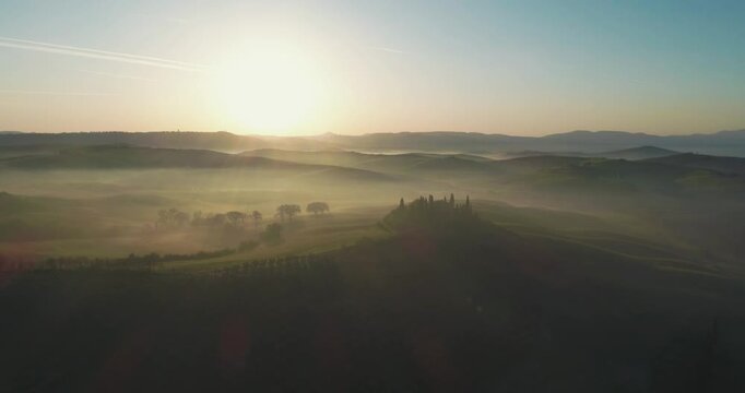 Classic Tuscany landscape with green hills and farmland country at sunrise. Aerial shot of green spring fields and hills in Tuscany, Italy