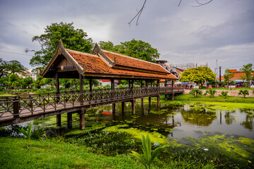 Obraz premium Traditional covered wooden bridge over pond in Siem Reap park