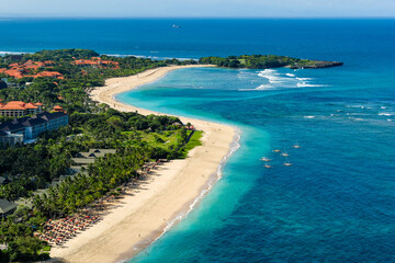 Traditional outrigger boats anchored in the clear blue sea off the coast of Nusa Dua