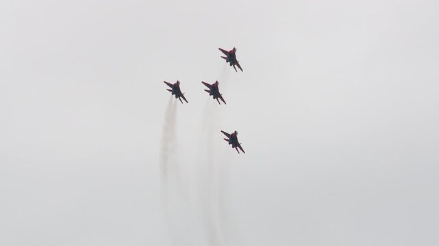 The Strizhi aerobatic team performs aerobatic maneuvers on MiG-29s against the backdrop of a gray autumn sky