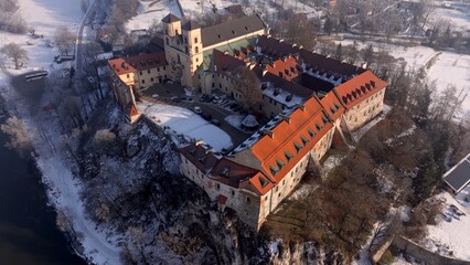Obraz premium Aerial view of Tyniec Abbey on a cliff overlooking the Vistula river in winter. 