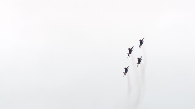 The Strizhi aerobatic team performs aerobatic maneuvers on MiG-29s against the backdrop of a gray autumn sky