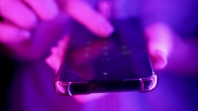 Close-up of hands entering a security pin code on a smartphone screen under rapidly changing strobe lights. Concept of cyber security, emergency communication, and digital privacy protection