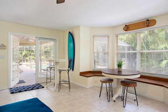 Breakfast nook with surf and skate decor that opens onto a pool deck