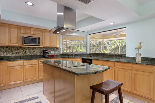 Spacious kitchen with stovetop island and granite countertops in a Florida vacation rental home