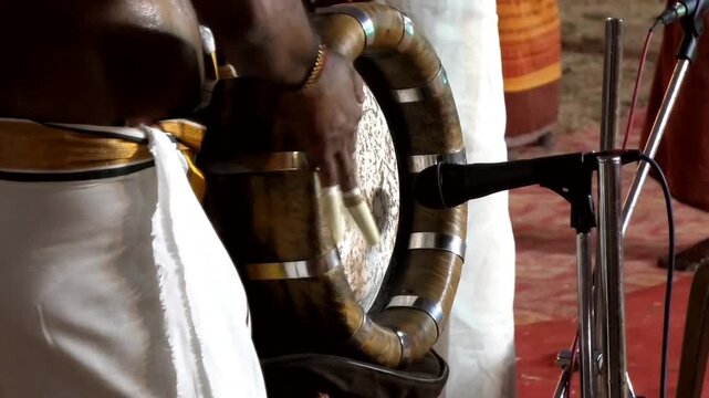 Closeup of an artist playing Thavil (Thakil), a South Indian percussion musical instrument during a temple festival celebration in Kerala, India