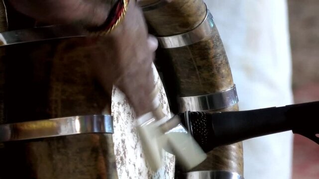 Closeup of an artist playing Thavil (Thakil), a South Indian percussion musical instrument during a temple festival celebration in Kerala, India