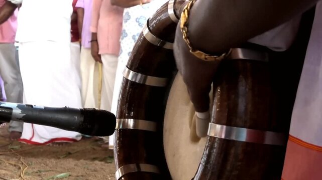 Closeup of an artist playing Thavil (Thakil), a South Indian percussion musical instrument during a temple festival celebration in Kerala, India