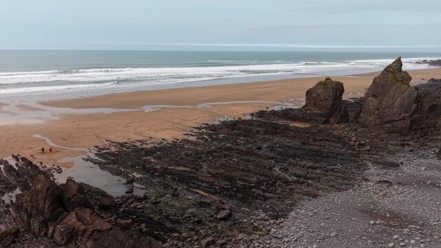 Drone flys over cliff revealing beautiful coastal Cornish landscape at Sandymouth Bay