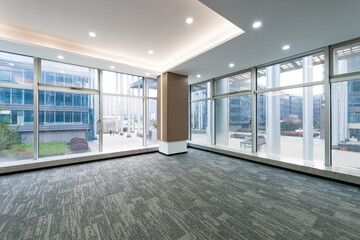 Naklejka premium Modern office interior with floor-to-ceiling windows and spacious empty layout
