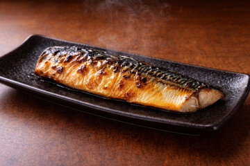 Japanese grilled mackerel fillet on a long black plate