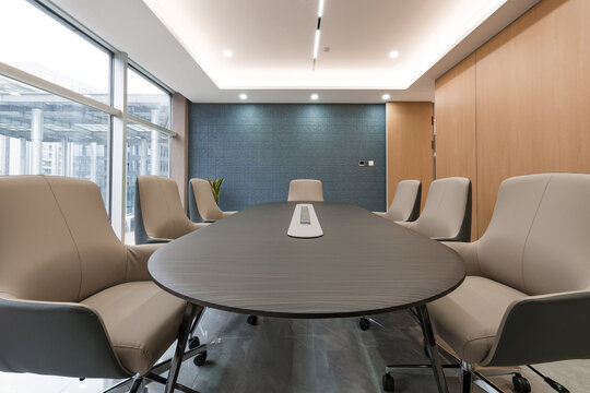 Modern office conference room with oval meeting table and leather chairs