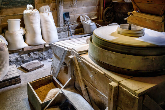 Inside the old wooden flour grinding mill. Interior of retro wooden watermill with old equipment for grinding or milling grain into flour