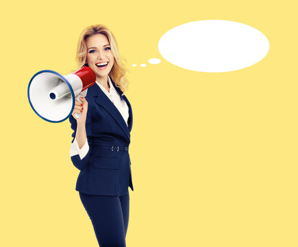 Expressive happy cute young business woman in suit, hold mega phone loudspeaker megaphone say, shout advertise. Blonde businesswoman, isolated yellow background. White empty speech bubble speechbubble