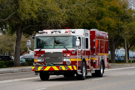 Large emergency fire engine driving through an American suburban road in Florida, capturing first responder action, municipal protection and rescue mobility