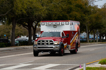 Front view of an American ambulance vehicle moving through a suburban road in Florida, capturing urgent healthcare response, rescue logistics and civic readiness © K