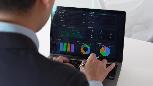 Businessman analyzing financial data on a laptop in a modern office