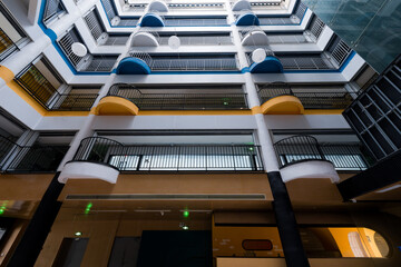 Naklejka premium Modern apartment building interior atrium with multi-level balconies and colorful architectural details