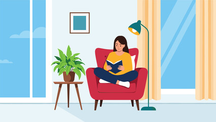 Fototapeta premium Relaxed young woman enjoys reading an interesting book while sitting cross-legged in a comfortable red armchair at home.