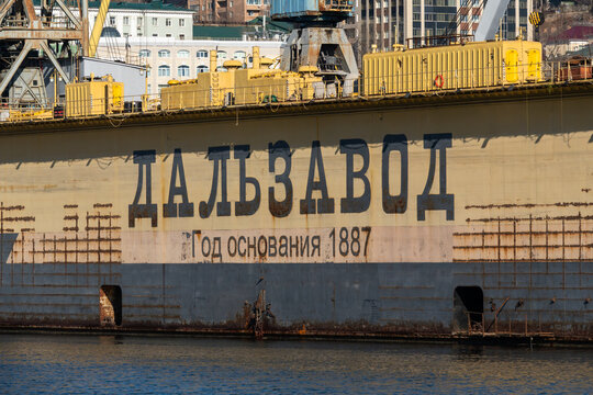 Vladivostok, Russia - February 16, 2026: Large industrial ship with the name "Dalzavod" and establishment year 1887 visible on the hull, docked in a harbor setting