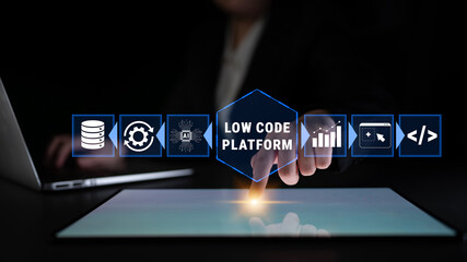 Hand Interacting with Low Code Platform Interface on Tablet Displaying Data Analytics, AI Tools, and Business Growth Solutions Under Dim Lighting Quark. © InfiniteFlow