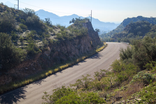Backlit shot of 7th Avenue curve between steep slopes of Tapatio cliffs, North Mountain Desert Park, Phoenix, AZ