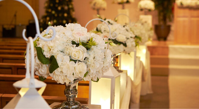 Elegant white floral arrangements on aisle seats in church