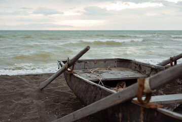 An old boat on the seashore. Cloudy weather.