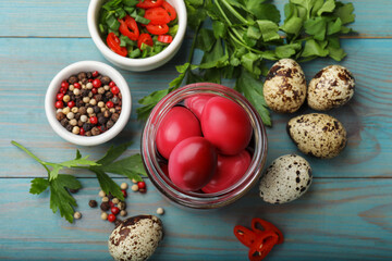 Pickled quail eggs and ingredients on blue wooden table, flat lay