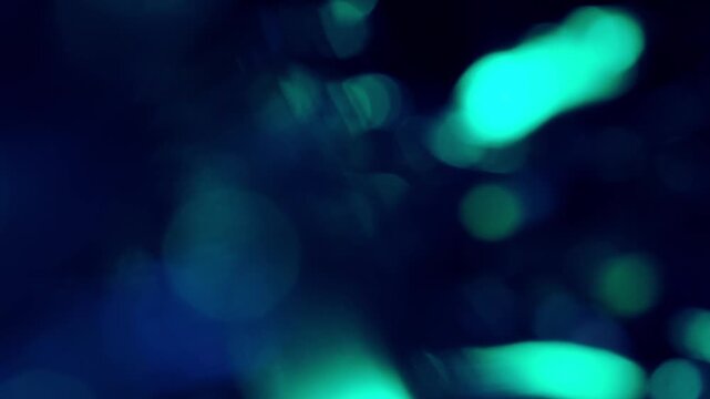 幻想的なターコイズブルーの大きな玉ボケが揺らめく抽象背景のループ映像