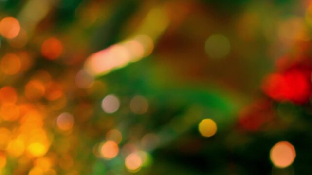 オレンジ色と緑色と赤色の小さい玉ボケが明滅しながら揺らめく抽象背景のループ映像