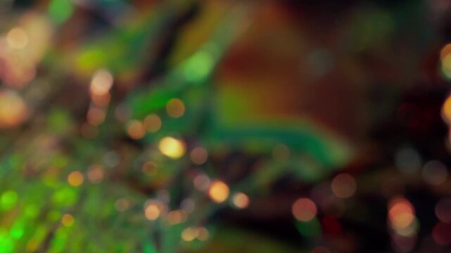 金色と緑色の小さい玉ボケが明滅しながら揺らめく抽象背景のループ映像